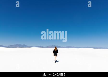 Donna che cammina sulle dune di sabbia dell'Alkali Flat Trail nel White Sands National Park, New Mexico, USA Foto Stock