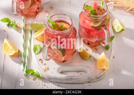 Limonata fredda e gustosa con agrumi, melone e ghiaccio tritato. Mojito con anguria e lime. Foto Stock