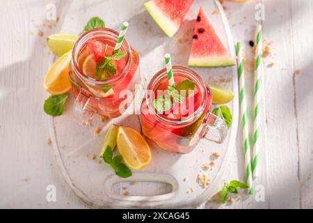 Limonata sana e gustosa con agrumi, melone e ghiaccio tritato. Mojito con anguria e lime. Foto Stock