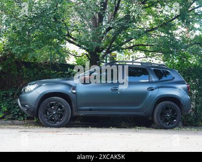 Bucarest, Romania - 15 giugno 2024: Nuova auto nera Dacia Duster parcheggiata vicino alla siepe verde Foto Stock
