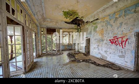 Camera abbandonata con tetto rotto, graffiti alle pareti e luce che entra dalle finestre, Villa Mussolini, Villa de vecchi, Profitis Ilias Foto Stock