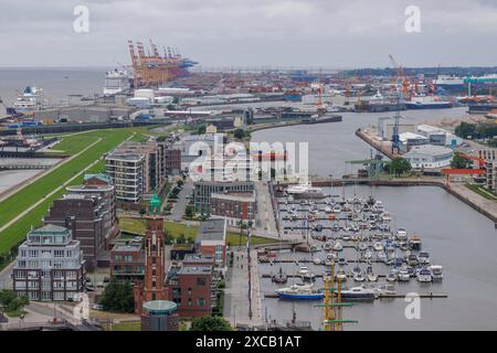 Sullo sfondo, Bremerhaven, Bremerhaven, Brema, Germania, si può vedere un porto affollato con molte navi e moli, gru e impianti industriali Foto Stock