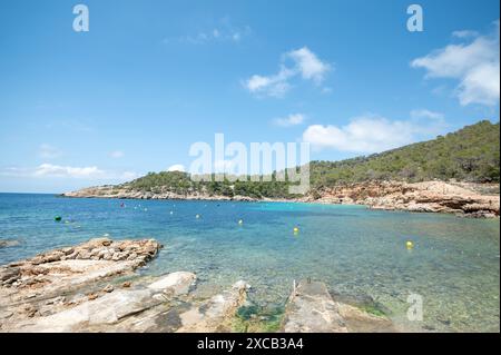 Cala Saladeta, Ibiza, Spagna: 2024 maggio 16: Persone sulla spiaggia di Cala Salada a Ibiza nell'estate 2024. A Ibiza nell'estate 2024. Foto Stock