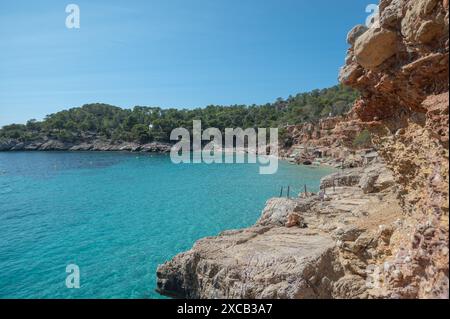 Acque turchesi di Cala Saladeta a Ibiza in estate. Foto Stock