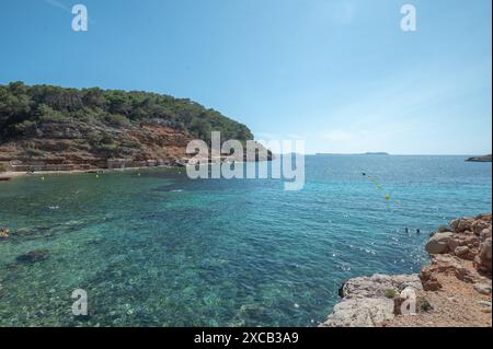 Acque turchesi di Cala Saladeta a Ibiza in estate. Foto Stock