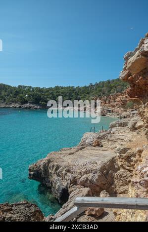 Acque turchesi di Cala Saladeta a Ibiza in estate. Foto Stock