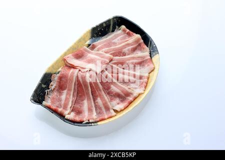 Piatto di manzo R​aw a fette con confezione in stile giapponese, prodotto supermercato, isolato su bianco Foto Stock