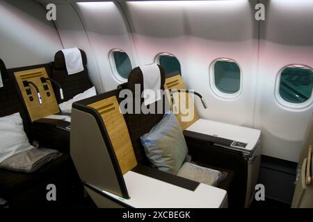 ZURIGO, SVIZZERA - 22 GIUGNO 2019: Cabina vuota con sedili business class con applicazioni in legno e tessuto marrone in un aereo a lungo raggio sul Foto Stock