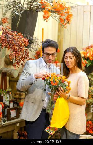 Giovane acquisto di ornamenti Natale nel centro giardino Foto Stock