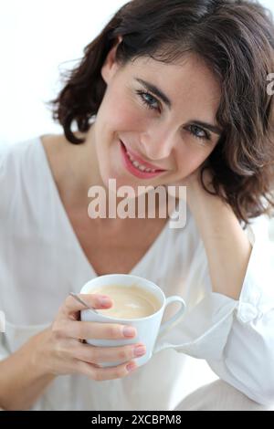 Ritratto di donna azienda tazza di caffè Foto Stock