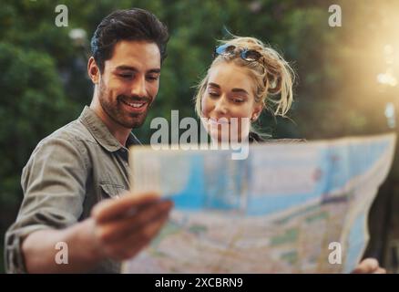 Viaggio, coppia e lettura mappa nella natura per avventure, vacanze o indicazioni stradali a Budapest. Turista, giovane donna e uomo felice con documento per Foto Stock
