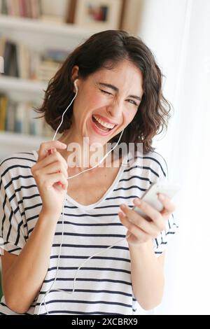 Donna ascoltando musica con lo smartphone Foto Stock