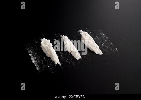 Polvere di cocaina in tre linee isolata su sfondo nero. illustrazione di sostanze stupefacenti illegali Foto Stock