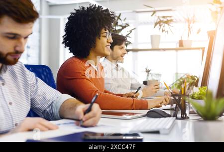 Gruppo di uomini che lavorano alla scrivania con computer Foto Stock