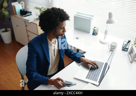 Serio uomo d'affari nero che lavora in ufficio Foto Stock