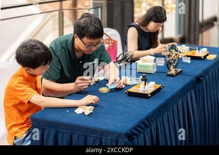 Shanghai, Cina. 16 giugno 2024. Le persone sperimentano le abilità dello smalto cloisonne presso le Grand Halls di Shanghai, Cina orientale, 16 giugno 2024. La prima giornata pubblica di apertura delle Grand Halls è stata inaugurata a Shanghai domenica, attirando molti visitatori. Composto da tre vecchi edifici con un'area di 99.000 metri quadrati, le Grand Halls in precedenza erano il molo del fiume Yangtze con una storia di oltre 100 anni. Crediti: Wang Xiang/Xinhua/Alamy Live News Foto Stock