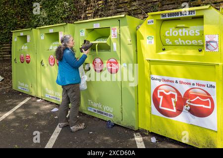 Cl.OTES e banca di scarpe per il riciclaggio con una persona che mette alcune scarpe in un parcheggio di supermercato, Abergavenny, Galles, Regno Unito Foto Stock