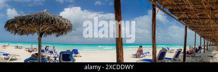 Santa Clara, Cuba-turisti che si godono la spiaggia paradisiaca. Ampia vista panoramica della spiaggia e dei vacanzieri sotto le capanne Foto Stock