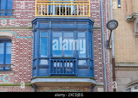 Balcone rosso delle case Belle Epoque lungo la costa francese Foto Stock