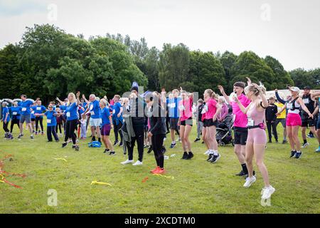 Warrington, Cheshire, Regno Unito. 16 giugno 2024. La "Race for Life" annuale a sostegno della Cancer Research UK si è svolta a Victoria Park, Warrington. Gli esercizi di riscaldamento sono stati eseguiti prima della gara crediti: John Hopkins/Alamy Live News Foto Stock