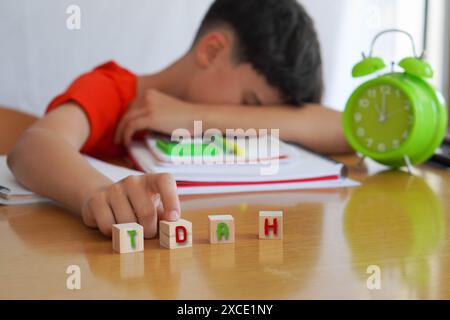 Bambino circondato da libri e quaderni frustrato, con l'acronimo ADHD, rappresenta la malattia disturbo da deficit di attenzione e le difficoltà che esso e Foto Stock