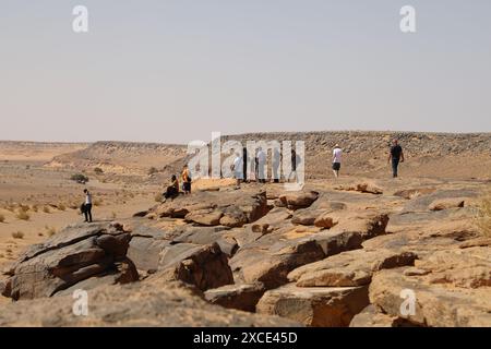 Turisti alla ricerca di petroglifi in un sito archeologico a Taghit in Algeria Foto Stock