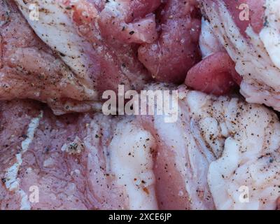 Vista ravvicinata della carne cruda marinata con sale e spezie. Foto Stock