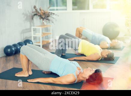 Gruppo di donne anziane che fanno pilates su mat in studio Foto Stock