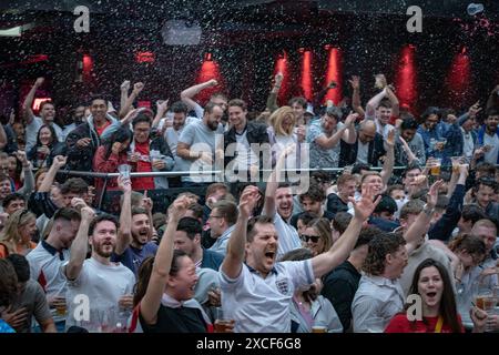 Londra, Regno Unito. 16 giugno 2024. EURO 2024: Inghilterra contro Serbia. La birra piove di gioia al 4TheFans Big Screen Event a North Greenwich dopo che il gol del centrocampista Jude Bellingham ha dato all'Inghilterra una vittoria per 1-0 nella gara di apertura di Euro 2024 contro la Serbia. Crediti: Guy Corbishley/Alamy Live News Foto Stock