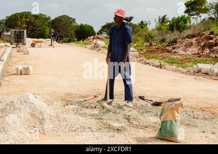 Uomini che mescolano la Malta nel cantiere stradale Foto Stock