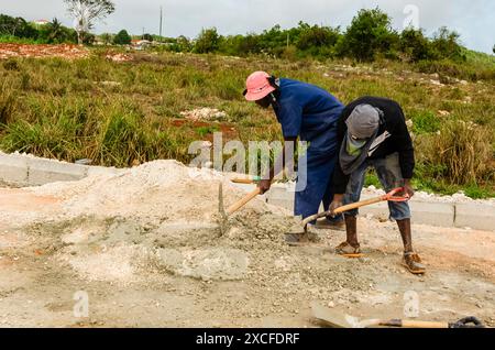 Uomini che mescolano la Malta nel cantiere stradale Foto Stock