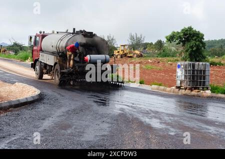 Distribuzione di petrolio su una nuova strada Foto Stock