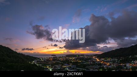 Vista aerea le nuvole oscurano lo splendido cielo mentre il sole tramonta. Le luci lungo la spiaggia iniziano ad accendersi quando il crepuscolo si avvicina. Ci sono molti edifici, Foto Stock