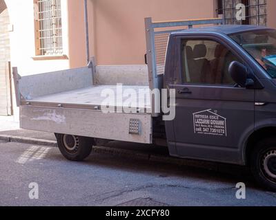 Cremona, Italia - 10 giugno 2024 il camion a pianale vuoto è parcheggiato in strada di fronte ad un edificio, pronto per la sua prossima consegna Foto Stock