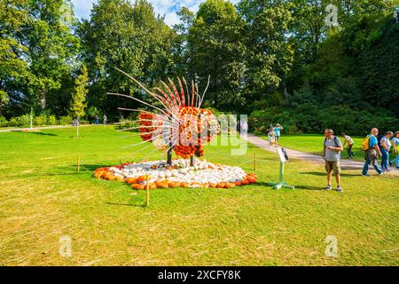 Ludwigsburg, Germania, 3 ottobre 2023, fiorenti giardini barocchi del palazzo decorati con migliaia di zucche, visitati dai turisti che ammirano un leone Foto Stock