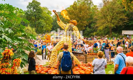 Ludwigsburg, Germania, 3 ottobre 2023, giardini barocchi in fiore pieni di turisti che ammirano la scultura della zucca sfiato del fuoco sputando fiamme Foto Stock