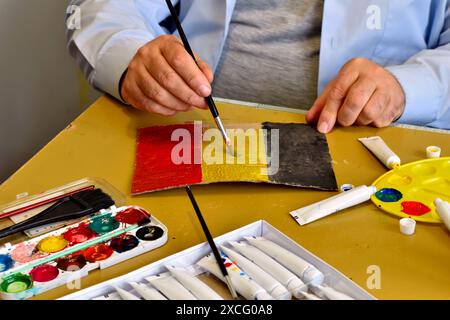 La bandiera del Belgio è disegnata dall'artista su un foglio di carta con acquerelli e un pennello. Foto Stock