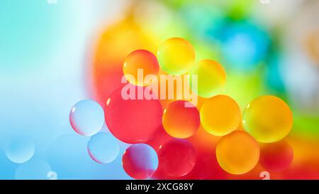 Gocce di olio in acqua e bolle d'aria, concentrazione selettiva. Sfondo arcobaleno fantasia multicolore luminoso. foto macro. Foto Stock