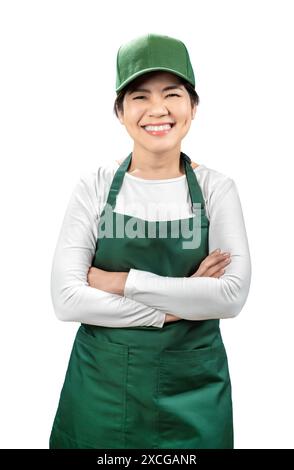 I venditori asiatici indossano grembiule verde e berretto verde sorridente e il braccio incrociato isolato su bianco Foto Stock