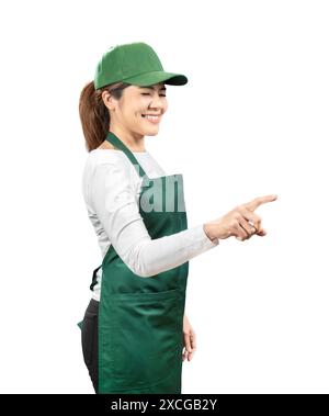 I venditori asiatici indossano grembiule verde e berretto verde sorridente e punta del dito isolata sul bianco Foto Stock