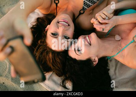 Due donne tengono le mani unite mentre si fanno un ritratto di se stesse. Foto Stock