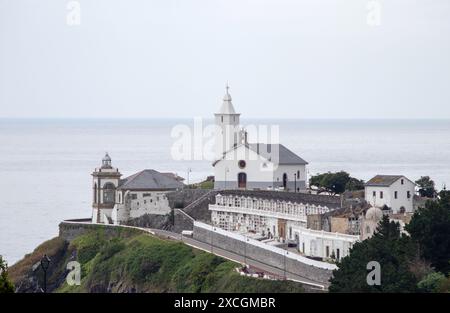 LUARCA, SPAGNA - 13 GIUGNO 2024: Chiesa di Capilla de Nuestra senora la Blanca, faro e cimitero in una giornata di tempo nuvoloso nel villaggio di pescatori di Luarca, va Foto Stock