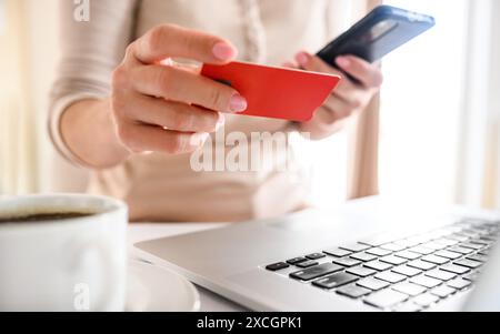 Ragazza con carta di credito e laptop che fa acquisti online. Donna che fa acquisti su Internet e paga con debito usando il computer Foto Stock