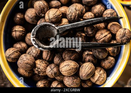 Noci e schiaccianoci nel primo piano del recipiente. Noci deliziose per l'epatite vegana dieta proteica e nutrizione Foto Stock