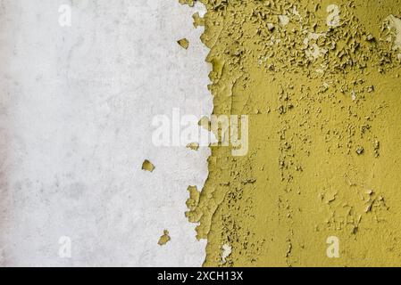 Struttura di un vecchio muro di cemento rotto con vernice gialla pelata Foto Stock