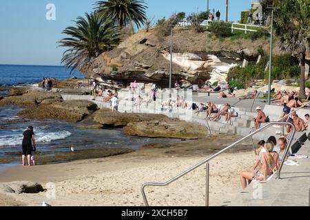 Gente del posto, gente del posto che prende il sole sulla piattaforma di cemento e scalini a South Cronulla B. in una giornata di cielo azzurro Foto Stock