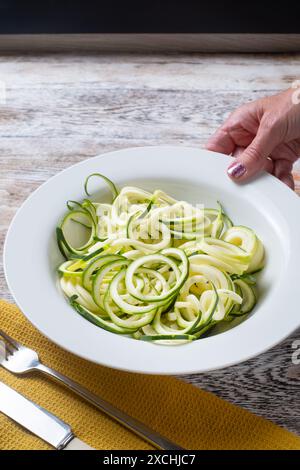 Una ciotola piena di zucchine o zucchine spiralate. Utilizzato come alternativa alla dieta Keto agli spaghetti e noto come zucchine, tagliatelle di zucchine o zoodles Foto Stock