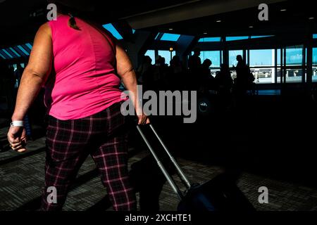 Passeggeri che trasportano una valigia con ruote all'aeroporto internazionale Pearson di Toronto, nella provincia dell'Ontario, in Canada, il 12 aprile 2023. Passagers voyag Foto Stock
