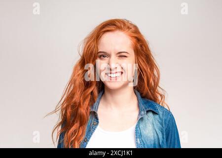 Radiosa giovane donna con capelli rossi che si avvolge Foto Stock