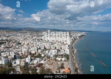 Vista aerea della città di Limassol con edifici moderni, cantieri edili, lungomare e mare Mediterraneo in una giornata di sole con nuvole Foto Stock